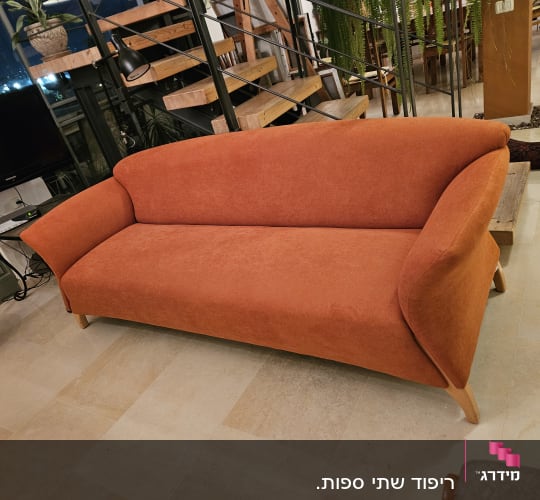 ספה כתומה עם ריפוד בד על רצפת שיש